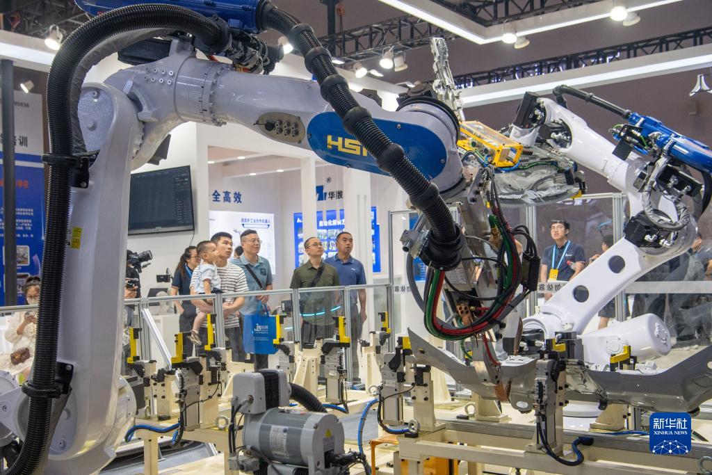 9月4日，在2023智博會(huì)華數(shù)機(jī)器人展廳，嘉賓參觀機(jī)器人工作設(shè)備。新華社記者 唐奕 攝